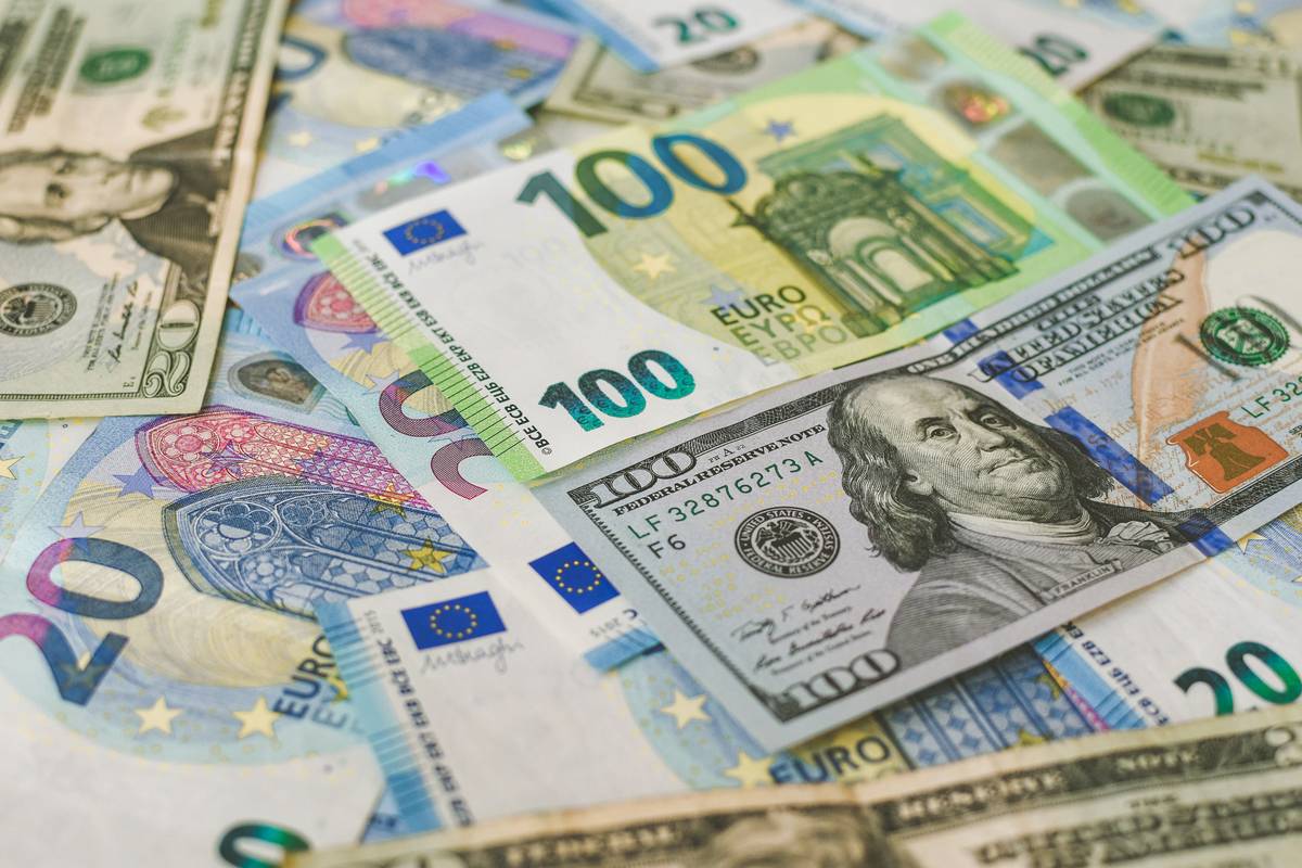 100 Euro (EUR), and 100 Dollar (USD) banknotes placed horizontally around other variety of banknotes.