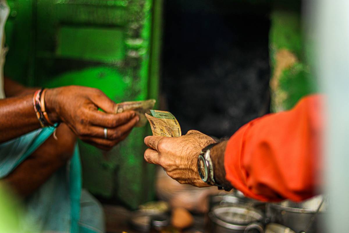 Traveler exchanging cash at your money exchange counter with visible rate board and receipt